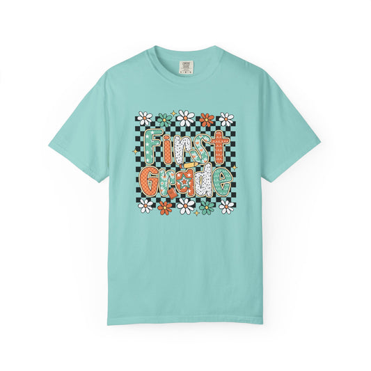 Light blue t-shirt with 'First Grade' text and floral design on a white background